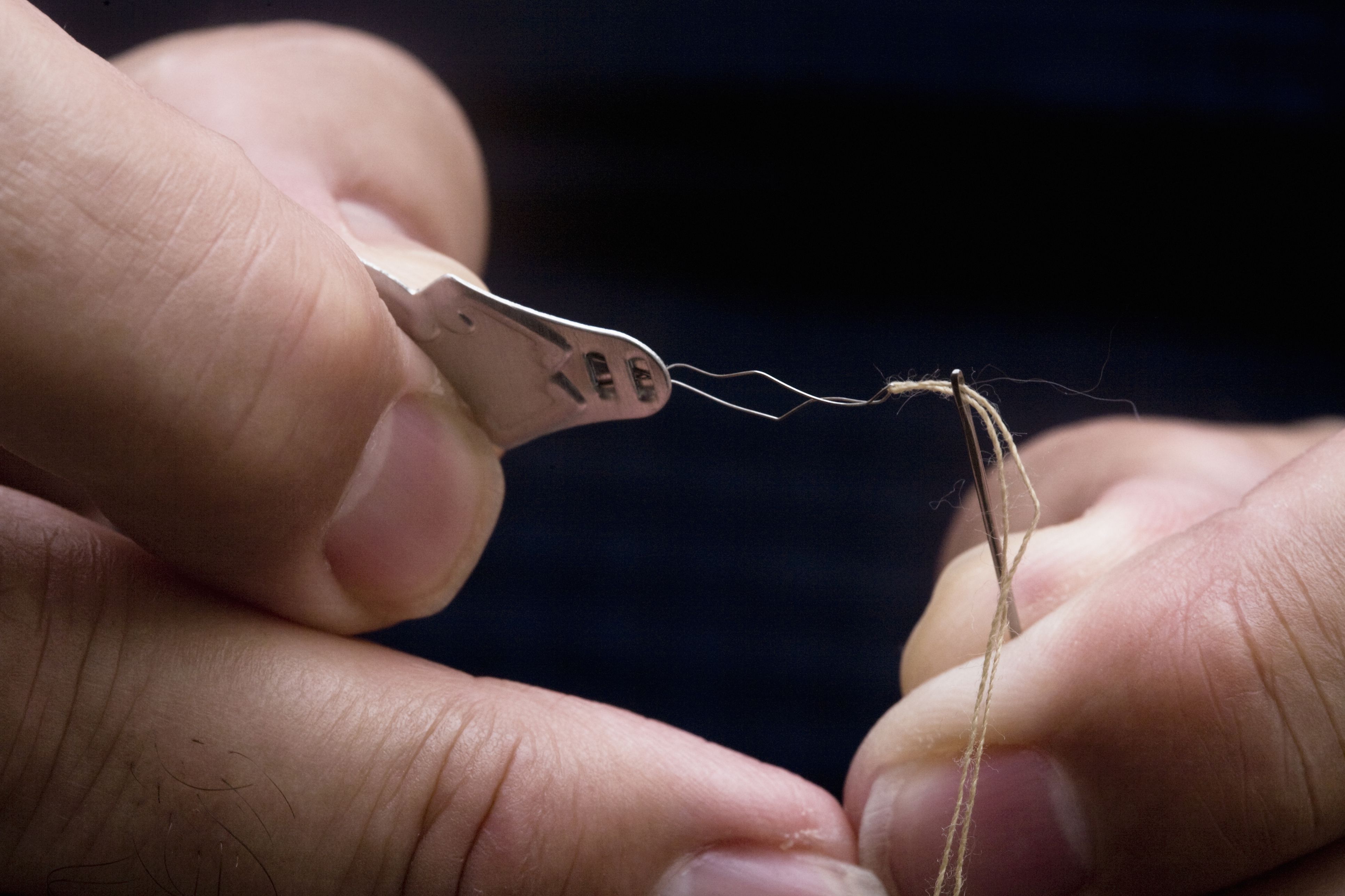 tailor inserting thread in a needle